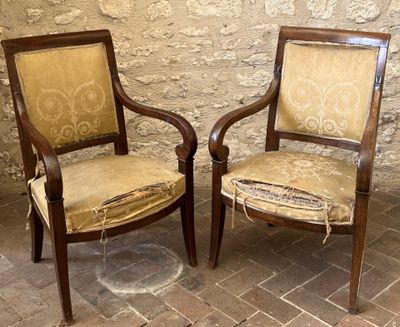 two chairs sitting next to each other on a brick floor