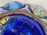 a blue glass bowl with a gold design on it