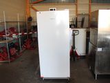 un réfrigérateur blanc entreposé dans un entrepôt avec d'autres appareils électroménagers