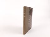 an old book with a brown cover sitting on top of a white surface