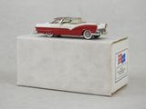 une maquette de voiture rouge et blanche posée sur une boîte