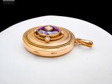 an image of a gold locke with a purple stone in it