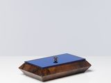 une petite boîte en bois avec un couvercle bleu, posée sur une table blanche