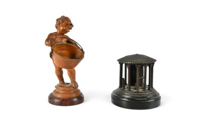 une petite statue représentant un garçon tenant un bol, à côté d'une petite statue représentant une femme