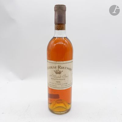 une vieille bouteille de whisky posée sur une table blanche