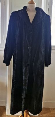 une image d'un manteau noir sur un support de mannequin
