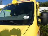 un camion jaune garé sur un parking, sur lequel figure un numéro