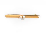 a close up of a gold tie bar with pearls on it