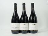 trois bouteilles de vin posées sur une table blanche
