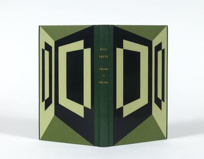 un livre ouvert, à la couverture verte, posé sur une table blanche