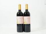 deux bouteilles de vin posées sur une table blanche