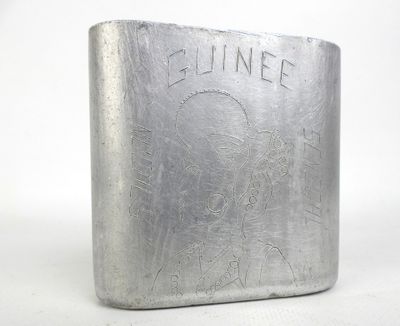 une vieille flasque en argent sur laquelle est représenté un homme