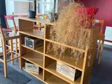a room with a table, chairs, and a book shelf