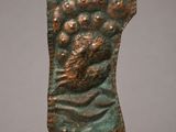 a bronze sculpture of a man ' s head on a rock