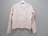 the pink sweatshirt is hanging on a hanger against a wall