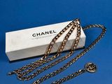 a chanel necklace with a box and chain on a blue background