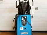 a blue pressurer sitting on the floor in front of a garage door