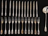a lot of forks and spoons on a black table