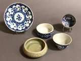 several pieces of blue and white pottery are sitting on a table