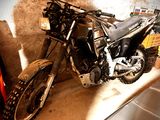 une moto garée dans un garage à côté d'une voiture