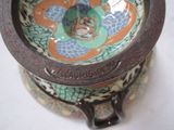 a close up of a bowl with a handle on a table
