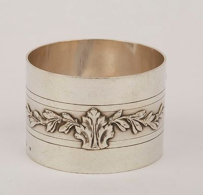 a silver cuff bracelet with a design of leaves and leaves on it