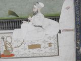 an old painting of a man sitting on a rug with a pipe in his hand