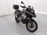 une moto noire garée dans une pièce aux murs blancs