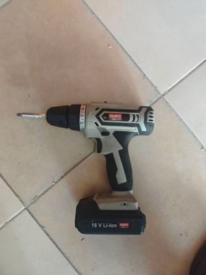 a cordless drill that is sitting on a tile floor