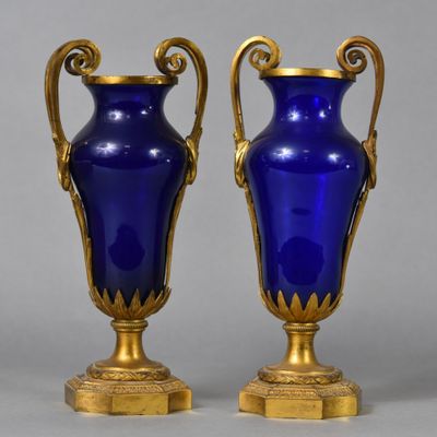 pair of blue glass vases with gold accents on stands