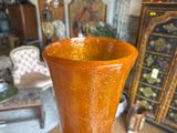 a large orange vase sitting on a table in a room