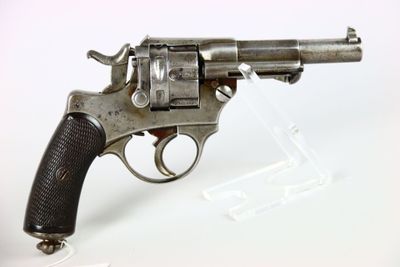 une vieille arme exposée sur une surface blanche, avec un fond blanc
