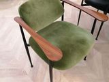 a green chair with a wooden armrest in a living room