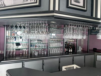 un bar avec de nombreux verres à vin sur les étagères