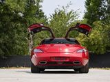 the rear end of a red sports car with its doors open