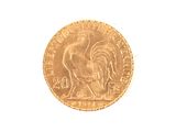 a gold coin with a rooster on it on a white surface