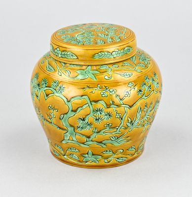 vase jaune et vert orné de fleurs et de feuilles sur le couvercle