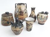 five vases and two cups sitting on a white surface