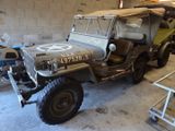 a military jeep parked in a garage next to other vehicles