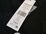black cable knit sweater with a tag on the back of it