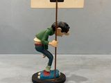 figurine of a young boy holding a sign on a pole