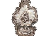 une assiette en argent sur laquelle est représenté un homme et une femme