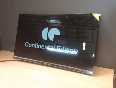 une télévision posée sur une table, avec une télécommande