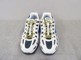 pair of white and blue sneakers with yellow laces on a gray surface