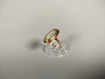 une photo d'une bague en or posée sur une assiette transparente