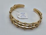 gros plan d'un bracelet en or sur une surface blanche