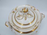 a white and gold pot with a lid on a white table