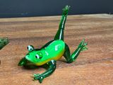 two glass frogs that are sitting on a wooden table