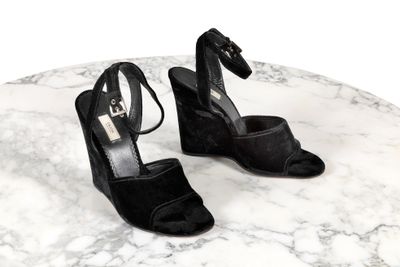 une paire de chaussures à talons hauts noires posée sur une table en marbre
