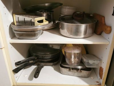 many pots and pans on the shelves in the kitchen